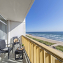 Balkon mit Blick auf die Ostsee und Sandstrand bei sonnigem Wetter.