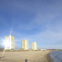 Hochhäuser am Strand von Fehmarn bei blauem Himmel und Meer.