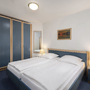 Schlafzimmer mit Doppelbett, blauen Schränken und Nachttischlampen.