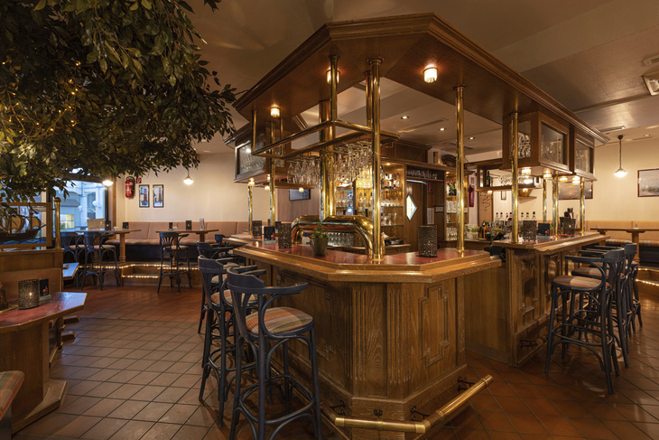 Gemütliche Hotelbar mit Holzmöbeln und geschmackvoller Beleuchtung.