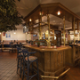 Gemütliche Hotelbar mit Holzmöbeln und geschmackvoller Beleuchtung.