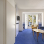 Zweiraum-Ferienwohnung mit Blick auf den Balkon und modernen Möbeln.