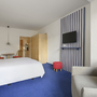 Helles Ferienwohnzimmer mit Bett, Sofa, TV und Esstisch in Binz auf Rügen.