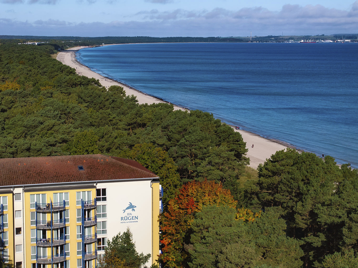Küste von Rügen mit Hotel und Wald im Vordergrund, Meer im Hintergrund.