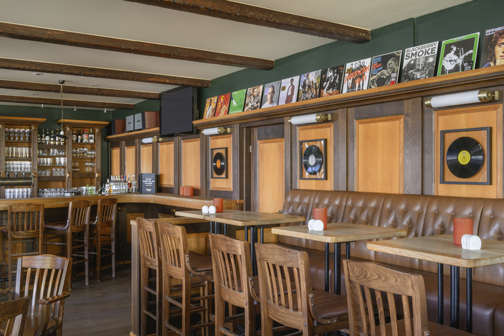 Restaurant mit Holzmöbeln und Wanddekorationen aus Schallplatten und Albumhüllen.