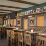 Restaurant mit Holzmöbeln und Wanddekorationen aus Schallplatten und Albumhüllen.
