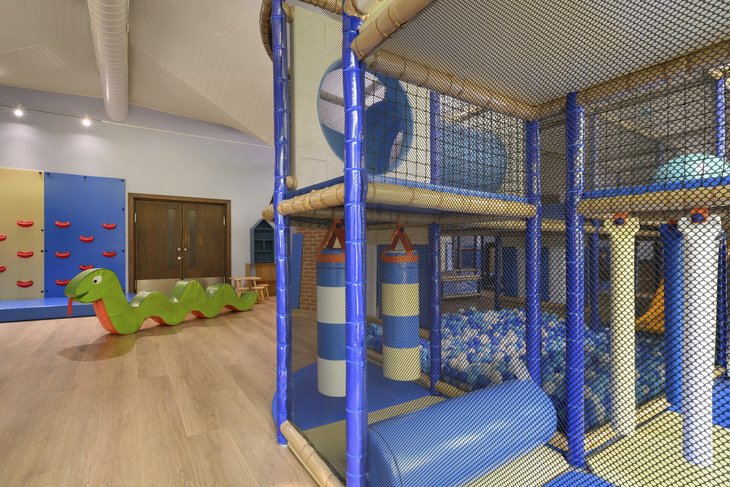 Indoor-Spielbereich für Kinder mit Kletterstruktur und buntem Spielzeug.
