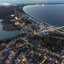 Luftaufnahme von Binz auf Rügen bei Abenddämmerung, Küstenlinie und beleuchtete Straßen.