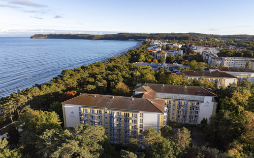 Luftaufnahme von Gebäuden am Waldrand bei der Küste auf Rügen in Binz.