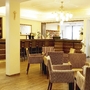 Foyer eines Kurhotels mit Sitzbereich und Bar, warme Farben.