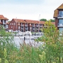Wohngebäude am Wasser in der Lagunenstadt Ueckermünde mit Booten im Hafen.