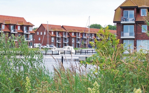Wohngebäude am Wasser in der Lagunenstadt Ueckermünde mit Booten im Hafen.