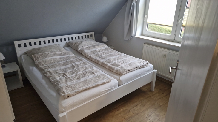 Ein Schlafzimmer mit einem Doppelbett und Dachschräge.