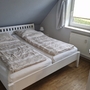 Ein Schlafzimmer mit einem Doppelbett und Dachschräge.