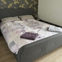Doppelbett mit bunter Bettwäsche und Handtüchern in einem Schlafzimmer.