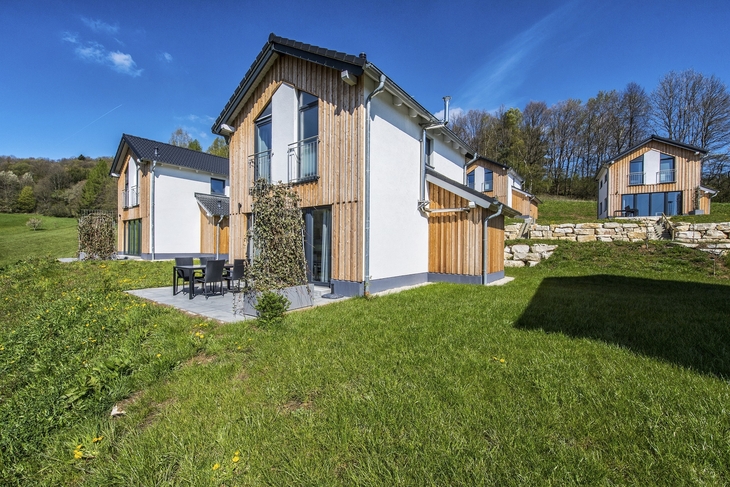 Ferienhaus in Feriendorf Obernsee mit Terrasse und Garten, umgeben von Natur.