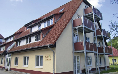 Mehrstöckiges Gebäude mit rot gedecktem Dach und Balkons in Zingst.