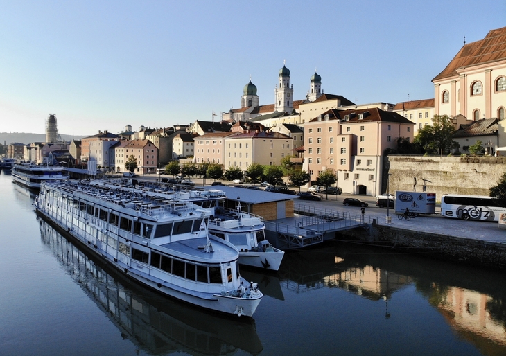 Hotel König Passau am Flussufer mit Blick auf Altstadt und Kirche im Hintergrund