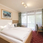 Doppelzimmer mit Doppelbett, Schreibtisch und Balkon im Hotel.