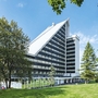 Hotelgebäude im Sommer, umgeben von Bäumen.