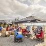 Strandlounge mit Sitzgelegenheiten aus Paletten und Sonnenschirmen am Ostseestrand.