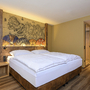 Superiorzimmer mit Doppelbett, Holzboden und dekorativer Wandkunst.