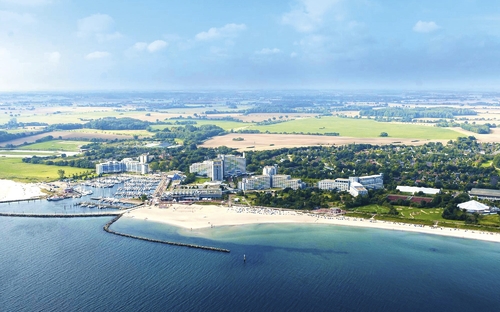 Luftaufnahme des Ostseeresorts Dampland mit Strand und Meer.
