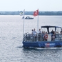 Eine Fähre mit Passagieren und Fahrrädern auf einem See.