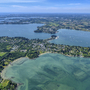 Luftaufnahme der Küste und Inseln im Golf von Morbihan, grüne und blaue Wasserflächen.