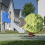 Spielplatz mit Wippgerät in Fischform vor Ferienanlage