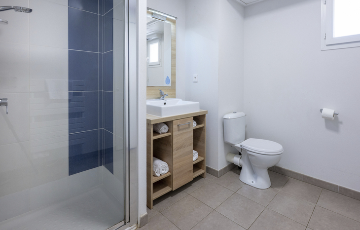 Modernes Badezimmer mit Dusche, Waschbecken und Toilette.