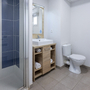 Modernes Badezimmer mit Dusche, Waschbecken und Toilette.