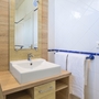 Badezimmer mit Waschbecken, Spiegel und Handtüchern.