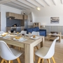 Essbereich und Wohnzimmer in einer modernen Ferienwohnung mit Holzmöbeln und Küchenzeile.