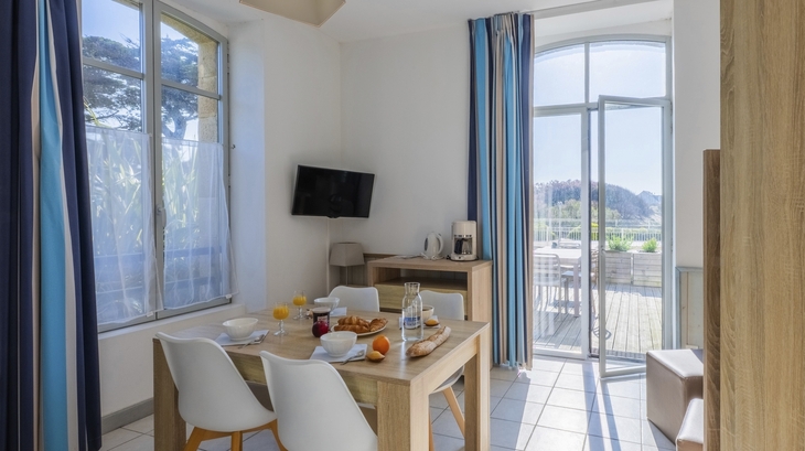 Esszimmer mit Tisch, Stühlen und Balkonblick in heller Ferienwohnung.
