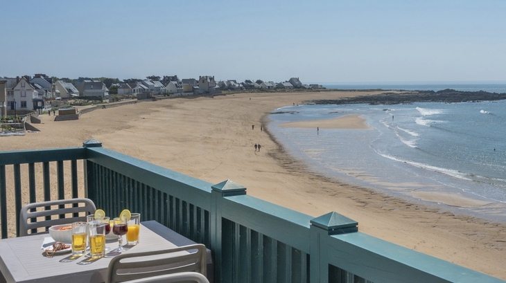 Strandvillen und gedeckter Tisch auf Balkon mit Meerblick bei Batz-sur-Mer.