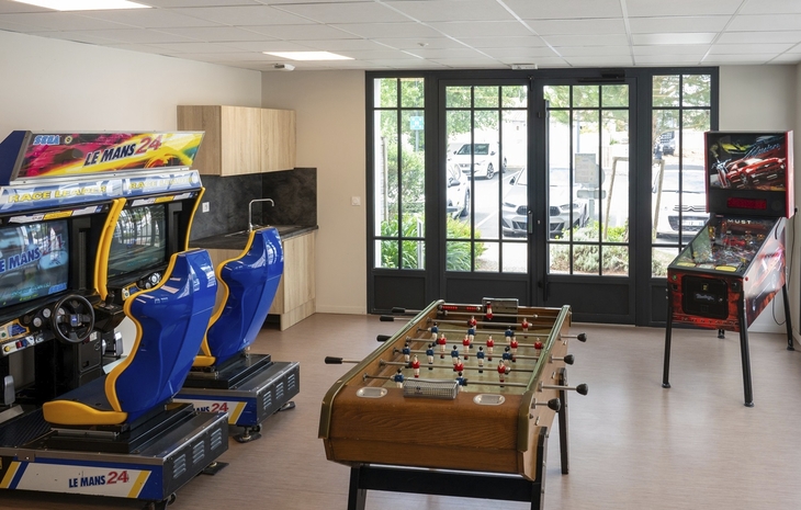 Spielraum mit Rennspielen, Tischfußball und Flipperautomaten.