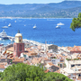 Blick auf Saint-Tropez mit Booten im blauen Meer und Hügel im Hintergrund.