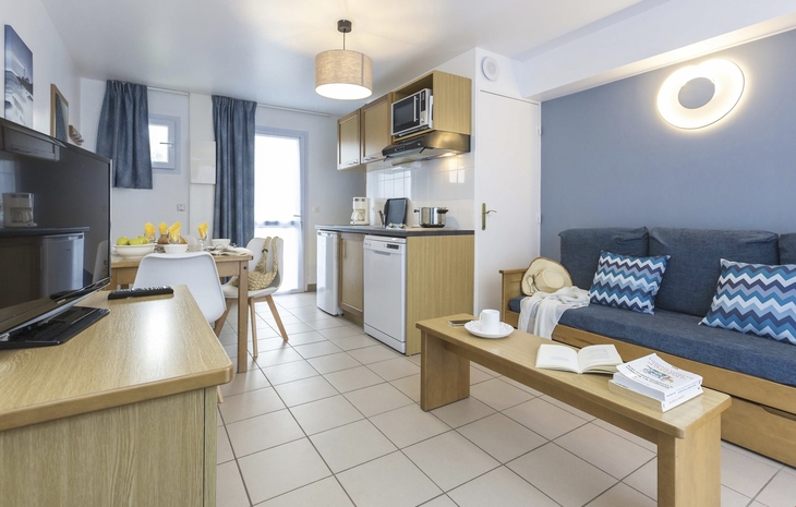 Helle Ferienwohnung mit moderner Einrichtung und kleiner Küche.
