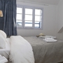 Doppelzimmer in der Résidence mit Bett, Fenster und blauen Vorhängen.