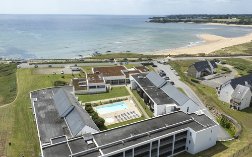 Luftaufnahme einer Ferienresidenz mit Pool nahe am Strand.