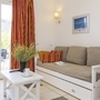 Wohnzimmer mit Sofa, Couchtisch und Blick auf Terrasse.
