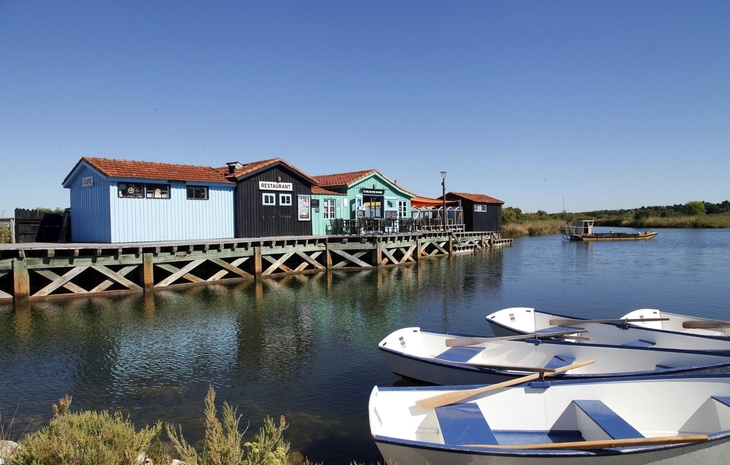 Boote vor bunten Hütten am Wasser auf der Île d'Oléron.