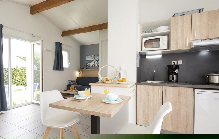Moderne Ferienwohnung mit Essbereich und Küchenzeile, heller Raum, Gartenblick.
