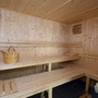 Innenansicht einer Holzsauna mit Bänken und Saunaeimer.