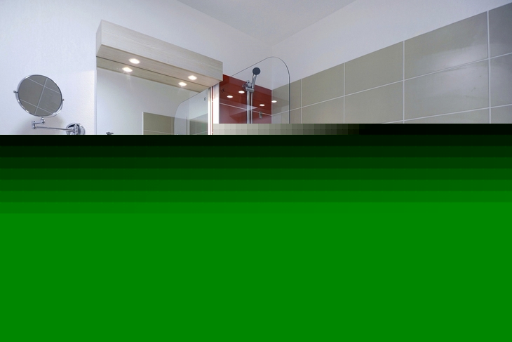 Modernes Badezimmer mit Badewanne, Spiegel und Wandkacheln.