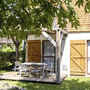 Terrasse eines Chalets mit Gartentisch und Stühlen im Grünen
