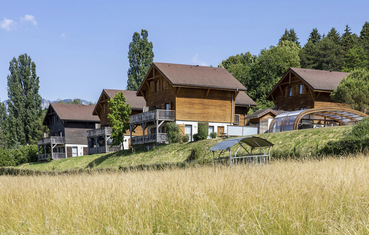 Chalets in Evian-les-Bains umgeben von Bäumen und Wiesen.
