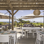 Terrasse eines Restaurants mit Tischen und Blick aufs Meer.