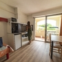 Frau in Studio-Apartment mit Balkon und Küchenzeile.